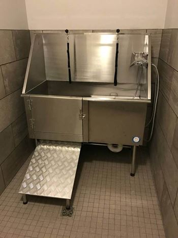 a stainless steel sink in a bathroom with a step in front of it at Grayhawk Apartments, Fargo